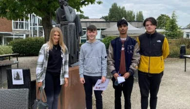 Graduates at Birmingham Newman in front of a tree
