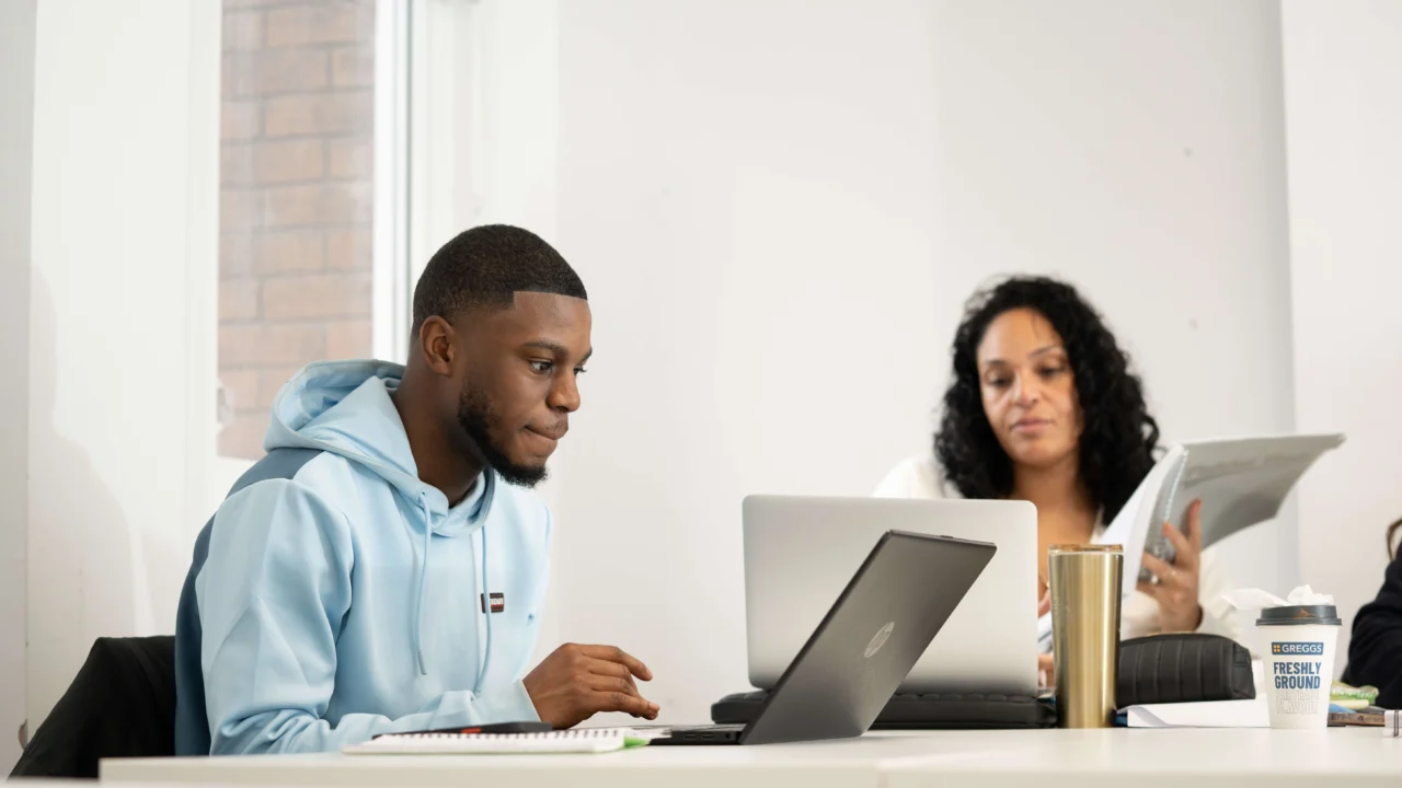 Business Management students in lecture with laptop
