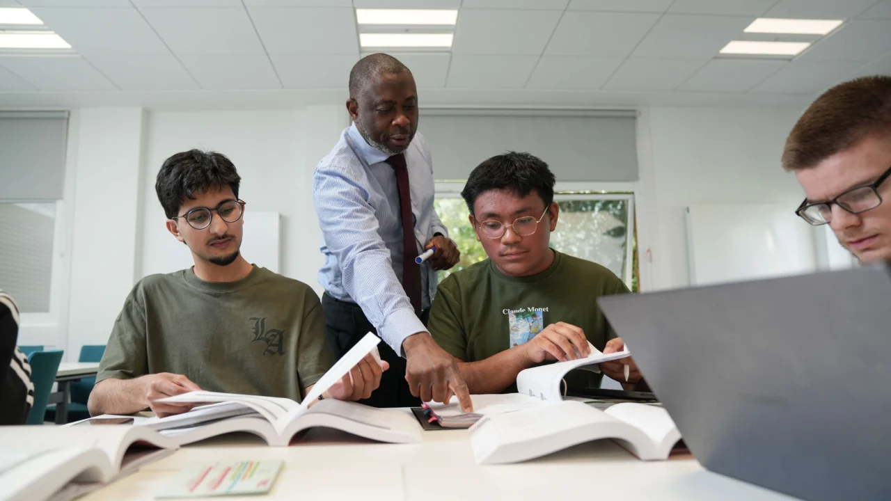 Business students in class with lecturer talking to them