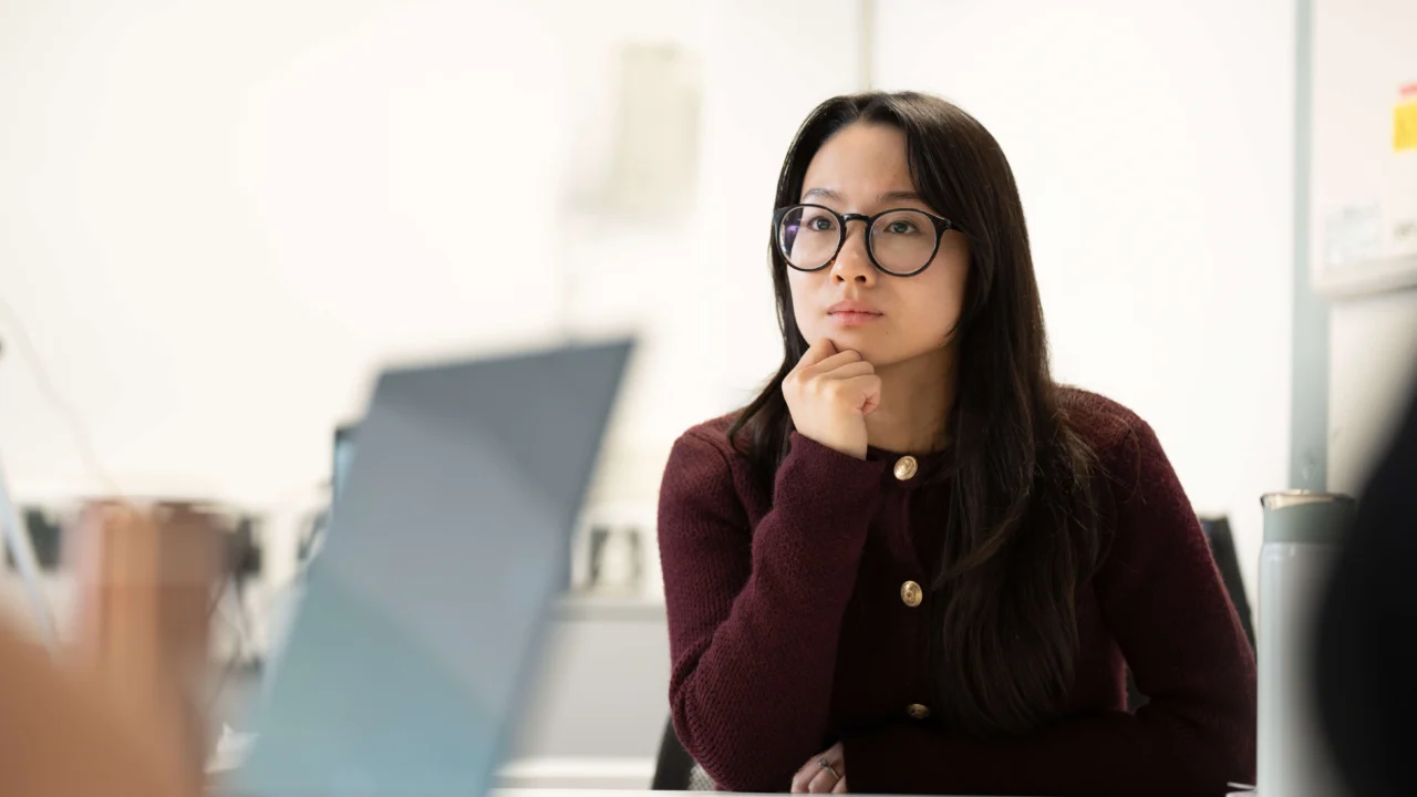 Student in class at table with laptop