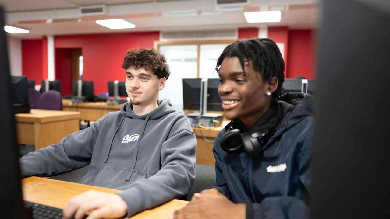 Two students working together in classroom on computer