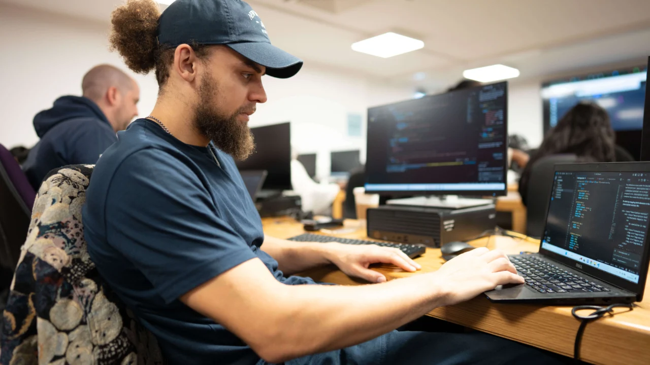 Student in classroom, working on laptop