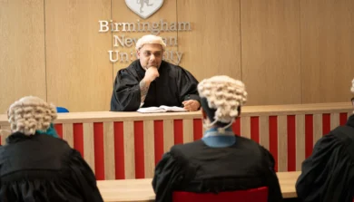 Courtroom setting with judges and person in witness stand