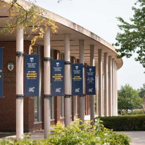 Front entrance of Birmingham Newman University with globe