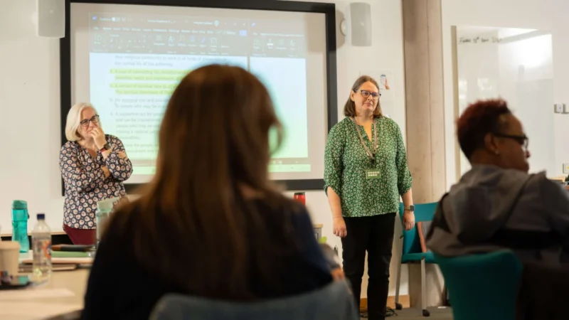 Backs of student in lecture facing lecturers