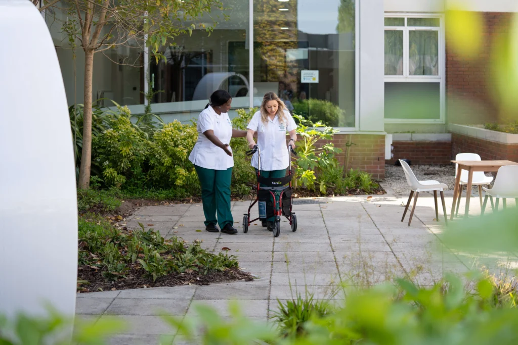 Occupational Therapy students in garden with walking frame