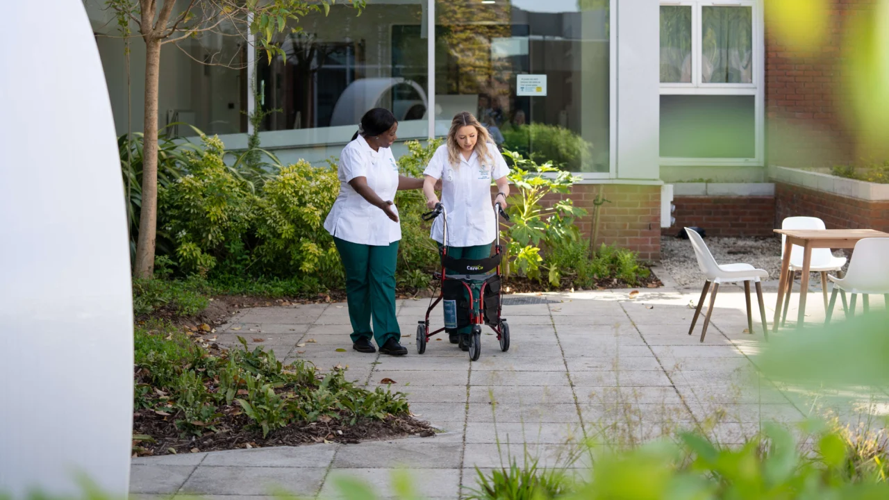 Occupational Therapy students in garden with walking frame