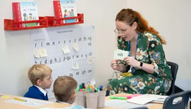 Primary education student teaching two young students
