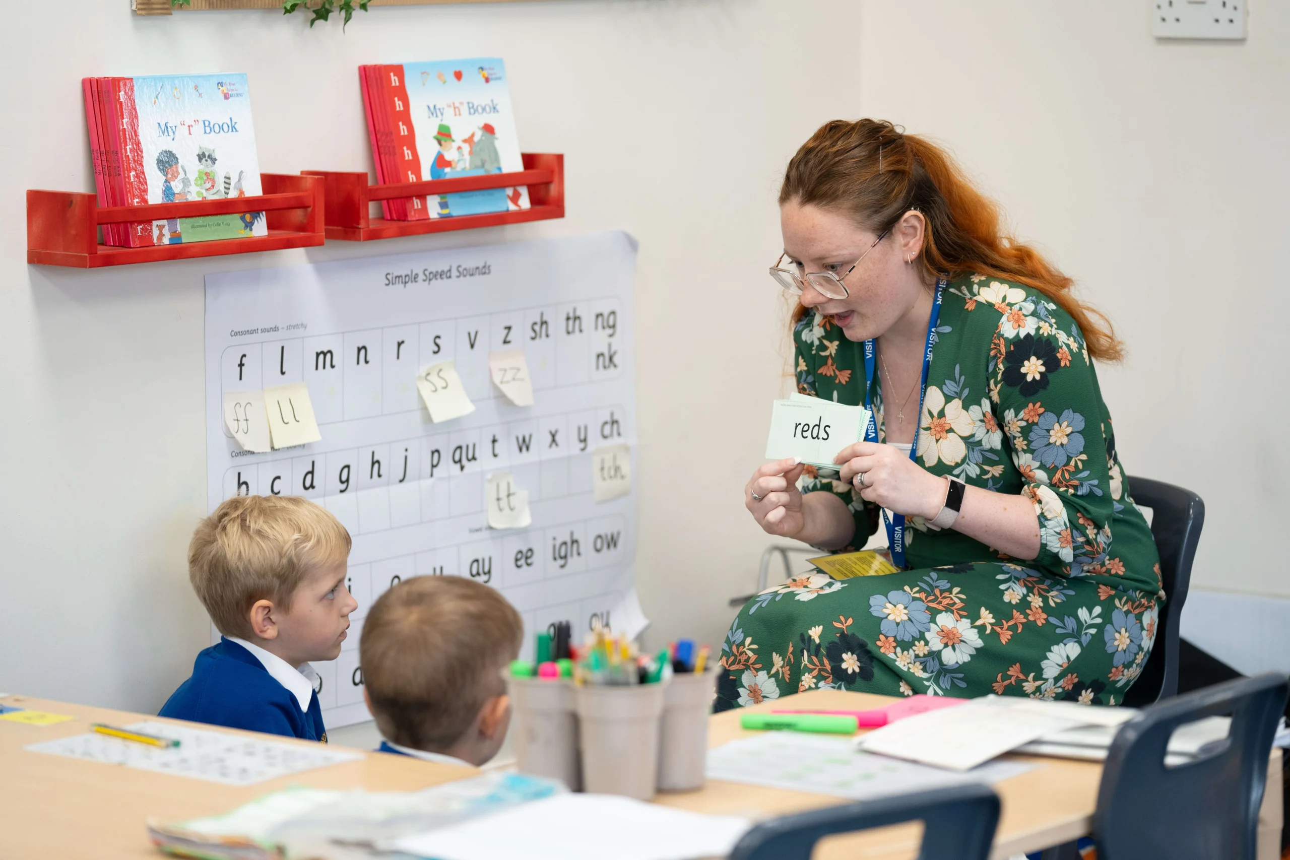 Primary education student teaching two young students