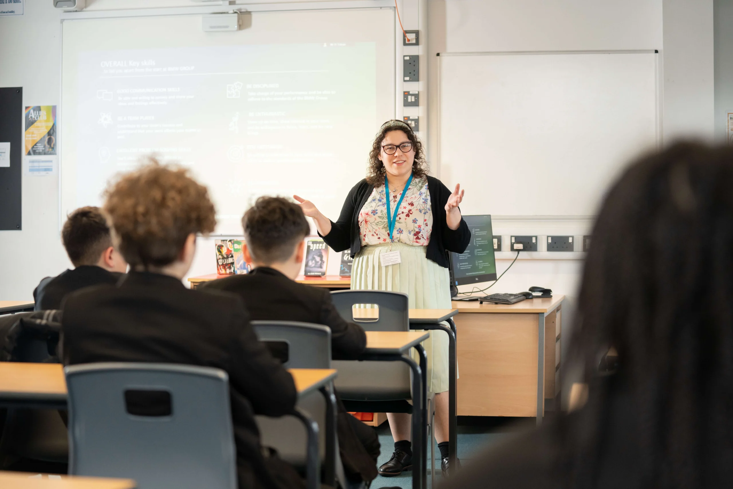 secondary school teacher at front of class talking to students