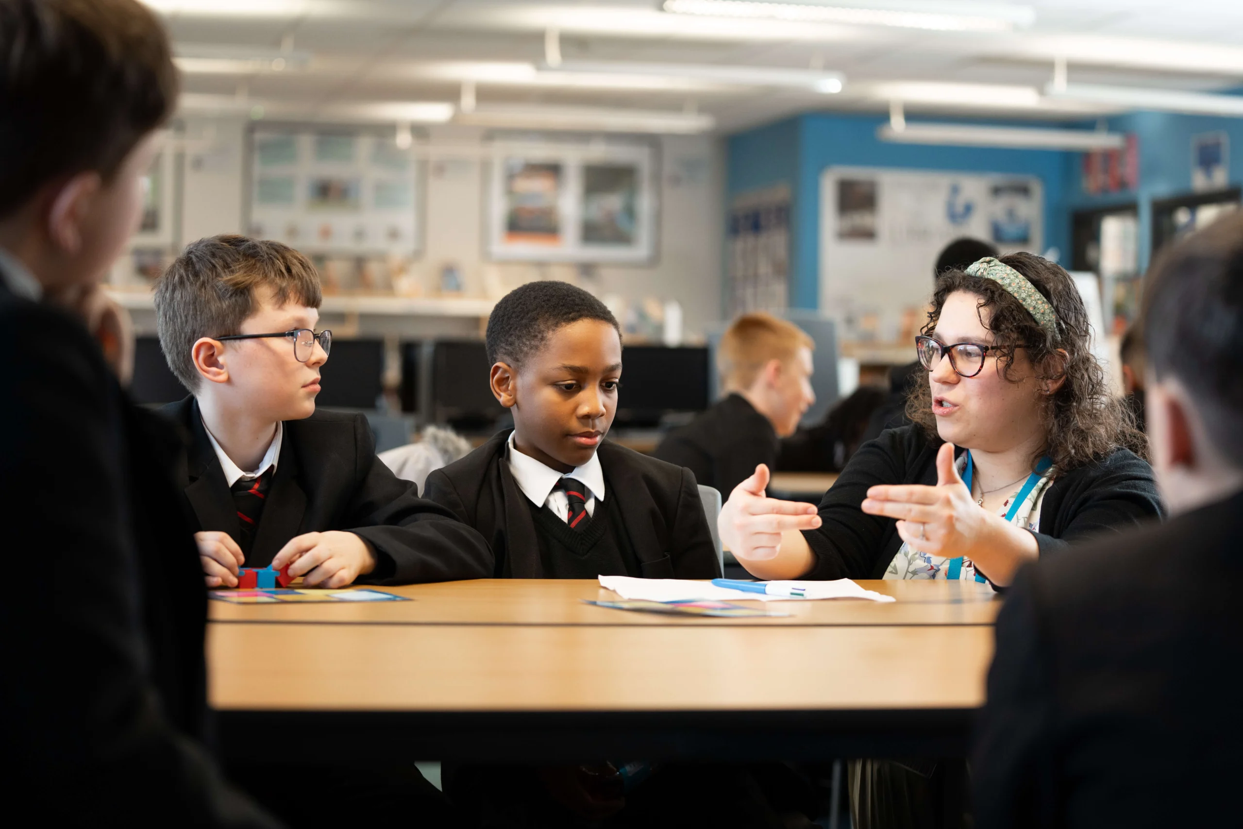 Primary school children with student teacher talking to them