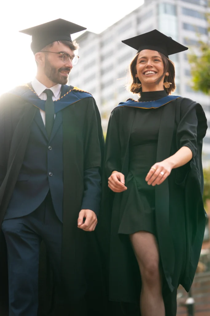 Two graduates outside after the Birmingham Newman Graduation ceremony