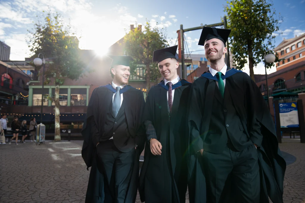 Three graduates outside after the Birmingham Newman Graduation ceremony