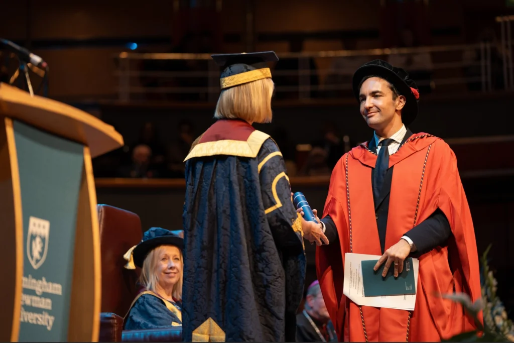Lewis Goodall in gown, receiving his Honorary Degree of Doctor of Letters