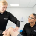 Two students at massage clinic at Birmingham Newman University