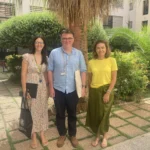 Image of outside Valencia campus gardens with 3 smiling people