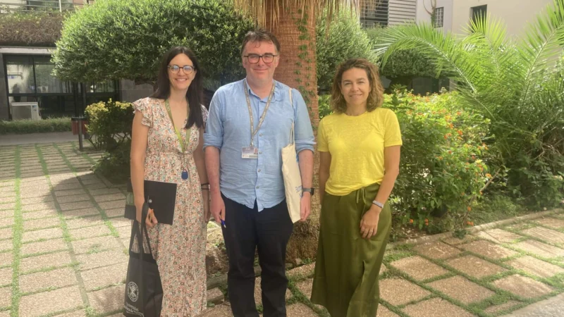 Image of outside Valencia campus gardens with 3 smiling people