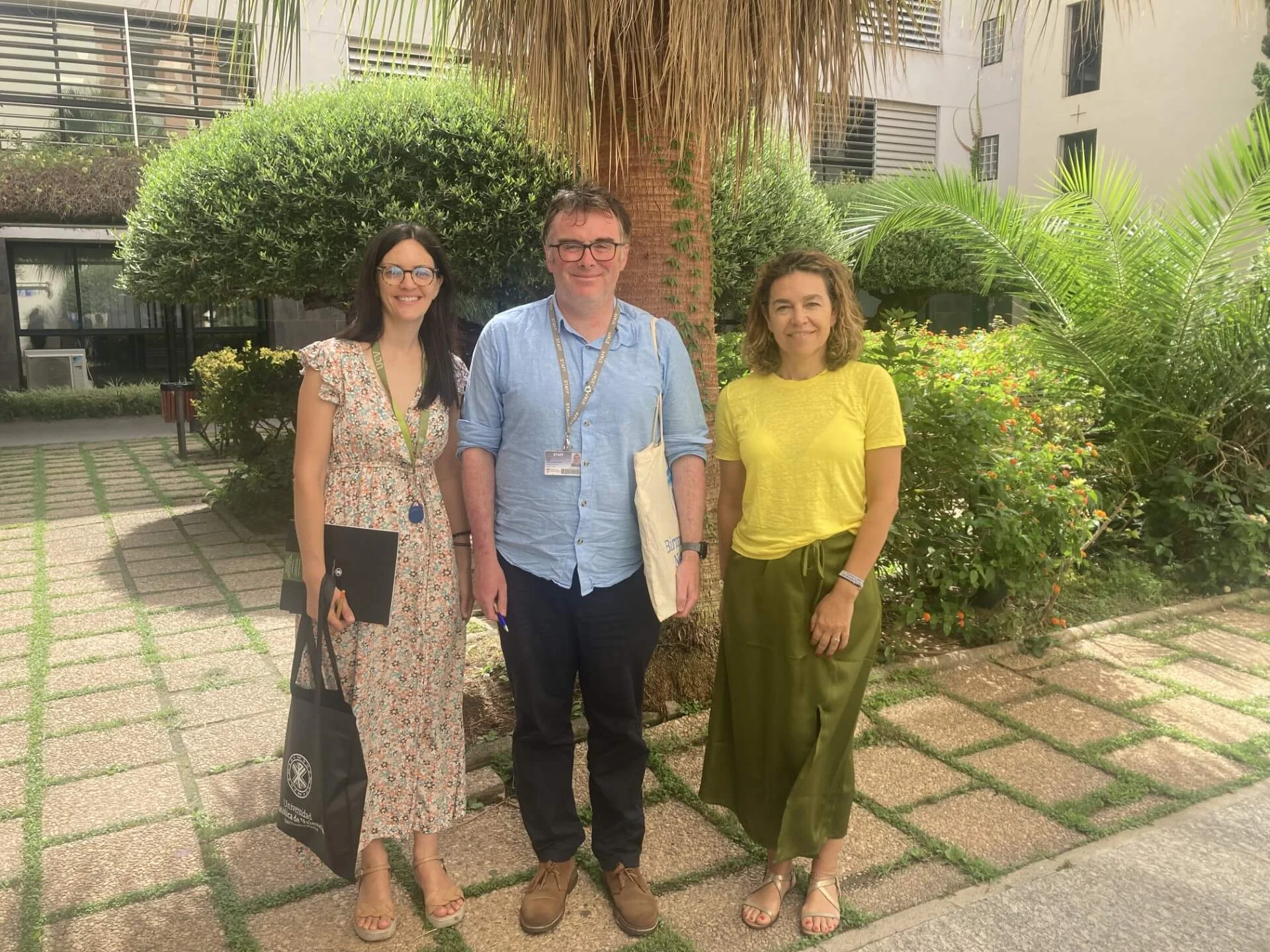 Image of outside Valencia campus gardens with 3 smiling people
