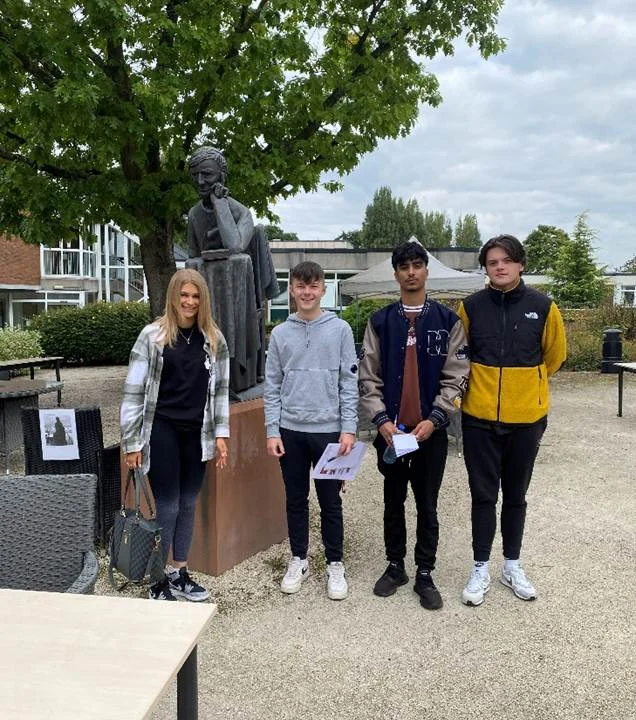 Graduates at Birmingham Newman in front of a tree