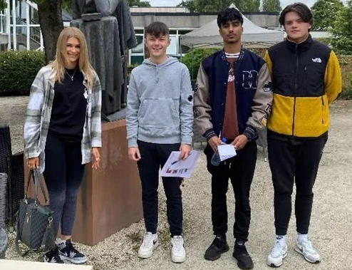 Graduates at Birmingham Newman in front of a tree