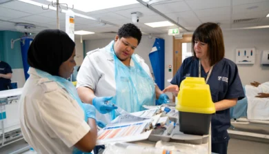 Students nurses in training ward being being shown information on clipboard