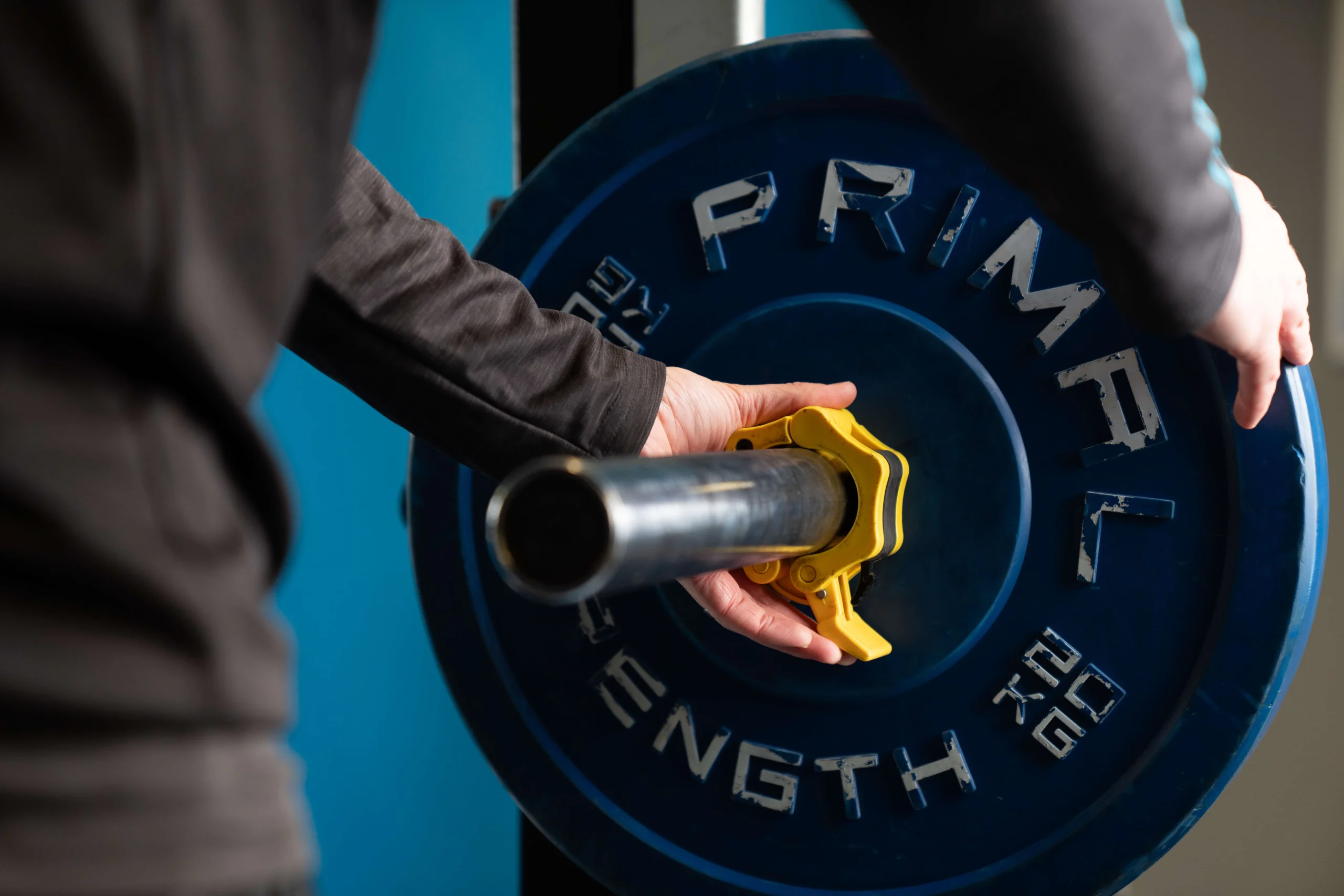 Sports student adjusting large weights in a gym setting