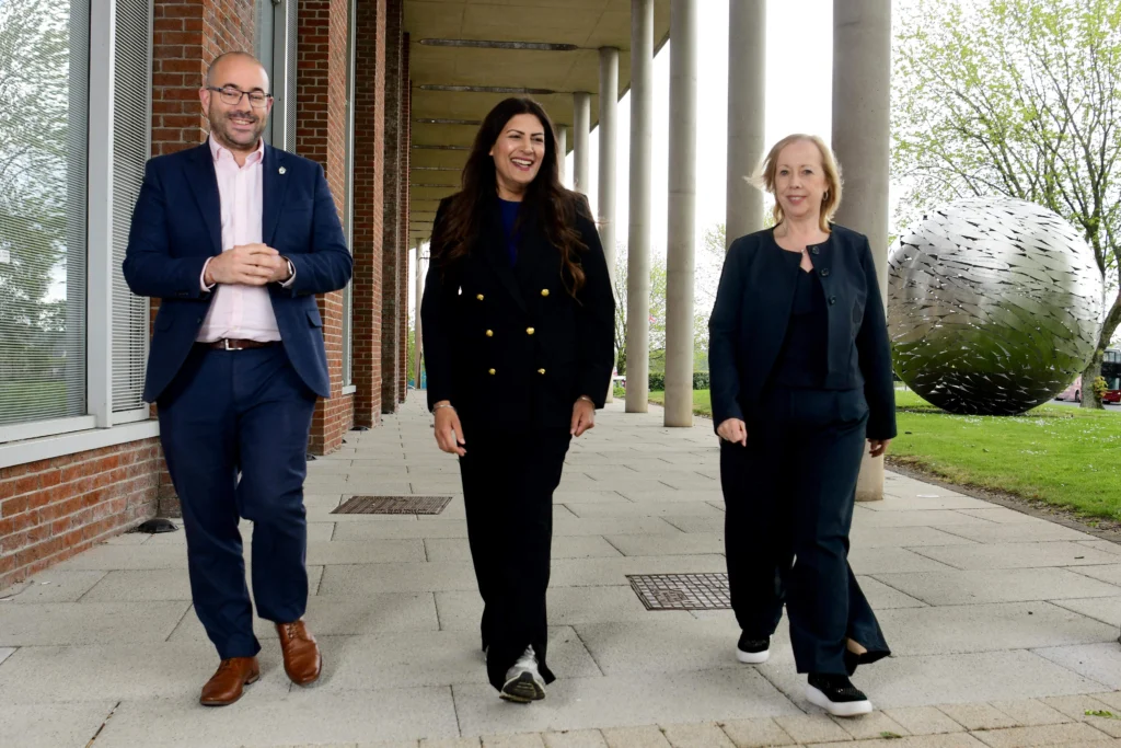 Professor Richard Medcalf, Preet Gill MP and Professor Jackie Dunne MBE walking and talking together outside Birmingham Newman University