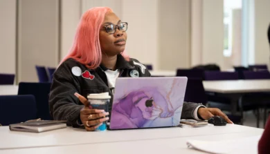 Applied Health and Social Care student in class with laptop