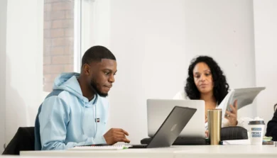 Business Management students in lecture with laptop
