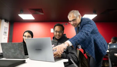 Computer Science student in class on laptop with tutor