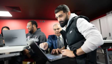 Computer Science students in class on laptop with tutor