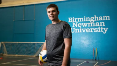 Student in sports hall with ball