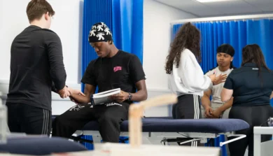 Sport and Exercise Therapy students working in a modern clinical setting, performing rehabilitation exercises and using therapy equipment.