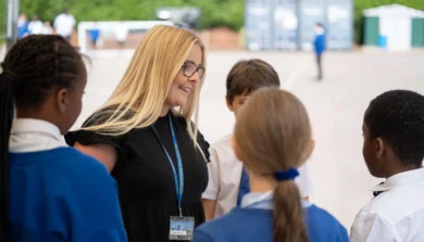 Teacher in a playground talking to a group of primary school children