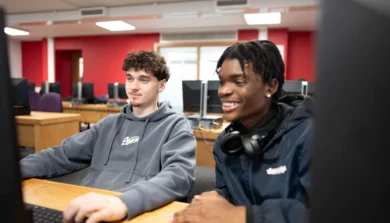 Two students working together in classroom on computer